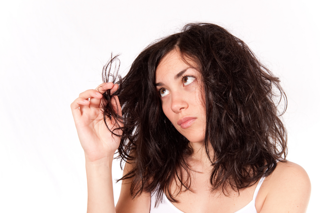 woman looking at hair and wondering if it is clean